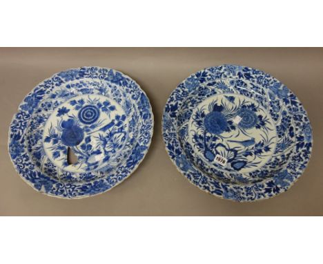 A pair of Chinese blue and white dishes, Kangxi, painted in the centre with a bird amongst flowering chrysanthemum, framed by