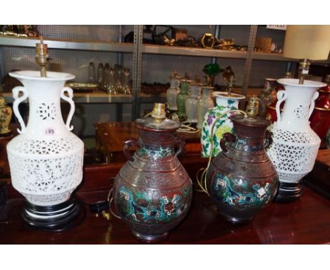 A pair of pierced white pottery table lamps and a pair of Asian enamel decorated table lamps, (4).  J3