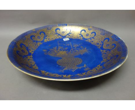 A Chinese powder-blue ground charger, blue Kangxi seal mark, but probably 19th century, finely gilt in the centre with a bask