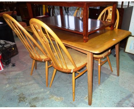 Ercol; a 20th century oak extending dining table with one internal leaf and a set of four stick back dining chairs, 136cm wid