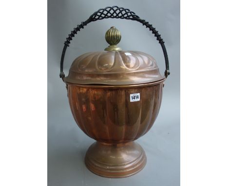 A copper brazier of lobed circular form, early 20th century, with brass finial and wrought iron swing over handle, 50cm high 