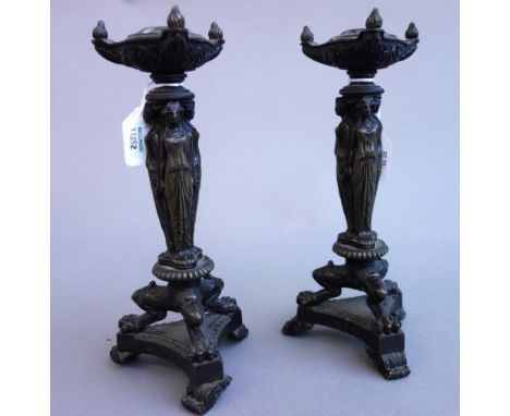 A pair of Empire style patinated bronze figural candle sticks, 20th century, each with lion paw feet on a triform base, 23cm 