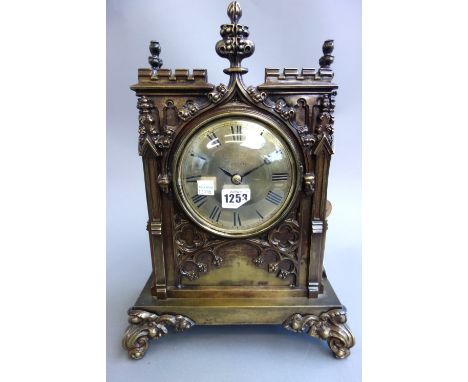 A Victorian brass mantel clock of Gothic 'cathedral' form, the brass dial detailed 'Scotty Co. London' enclosing a single tra