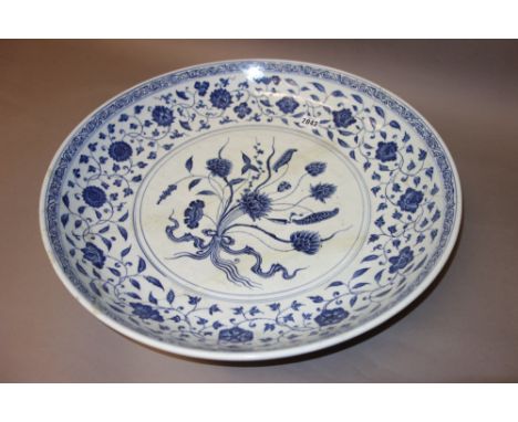 A large Chinese blue and white dish in Ming style, probably 18th century, painted in the centre with a tied lotus bouquet, be