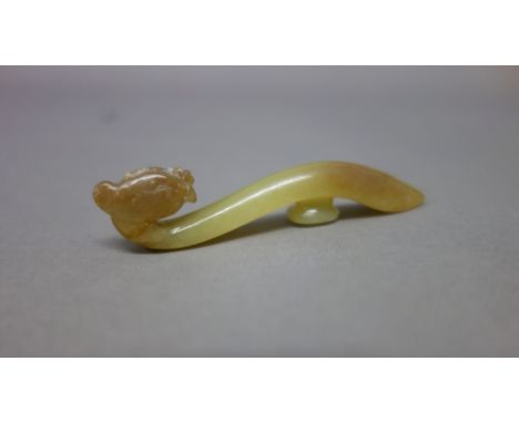 A Chinese yellow jade `phoenix' belthook, Tang Dynasty, finely carved with a phoenix head forming the end of the hook, the sh