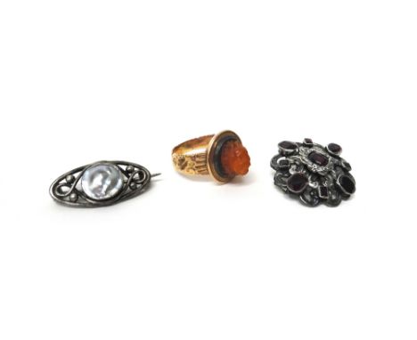 A gold and carved cornelian ring designed as the head of a lion, probably European, mid-19th century, ring size N, a garnet s