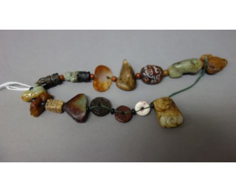 A collection of fifteen small Chinese jade carvings, probably Song Dynasty and later, comprising miniature bi discs, monks, m