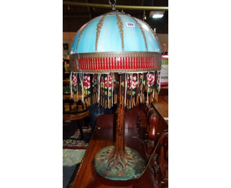 In the manner of Tiffany, a large 20th century table lamp with naturalistic cast iron base formed as a rooting tree, with a b
