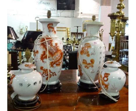 A pair of Asian ceramic vases converted to lamps, decorated with red dragons and script and a similar smaller pair, (4).  G5