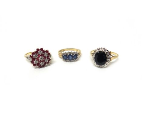 A 9ct gold, ruby and diamond ring, in a multiple cluster design, a 9ct gold, sapphire and diamond set oval cluster ring and a