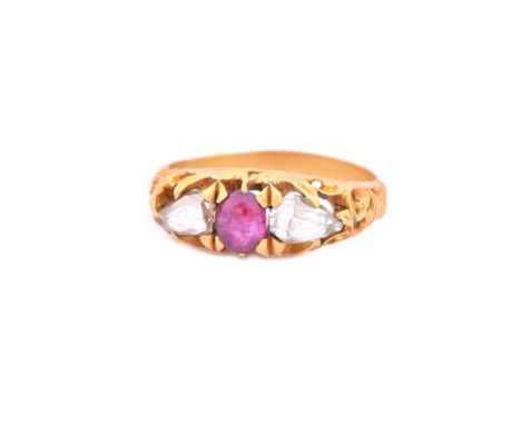 A gold, ruby and diamond set three stone ring, mounted with the oval cabochon ruby to the centre between two rose cut diamond