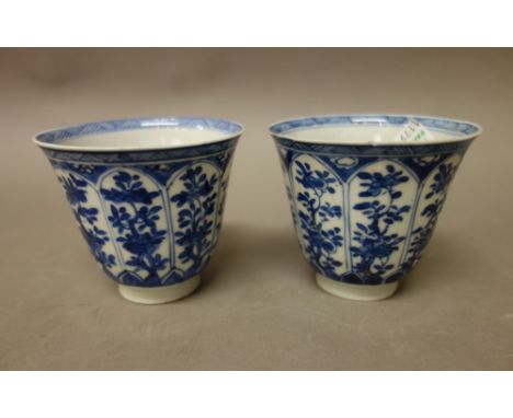 A pair of Chinese blue and white porcelain beakers, Kangxi, painted with panels of flowering plants, (a.f); also a pair of si