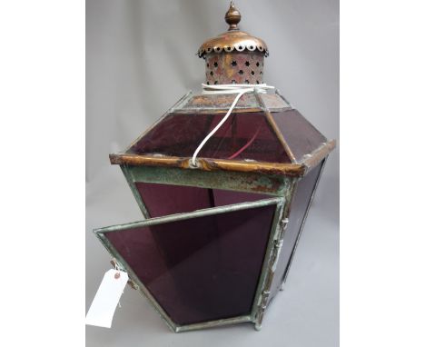 A Victorian copper lantern (later coloured glazing), of square tapering form, with a black painted wrought iron wall bracket,