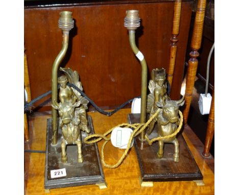 A pair of brass table lamps modelled as classical figures riding bulls, a pair of table lamps formed as Eastern deities and a