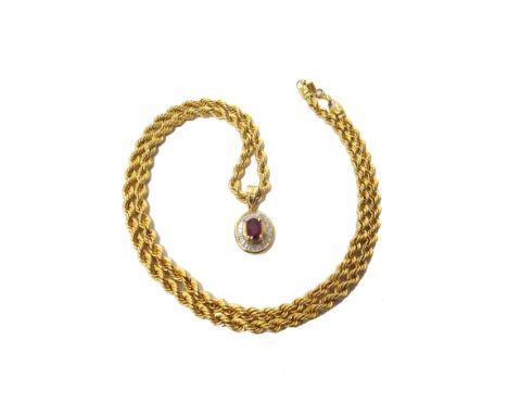 A gold, ruby and diamond set oval pendant, claw set with the oval cut ruby at the centre in a surround of calibre cut diamond