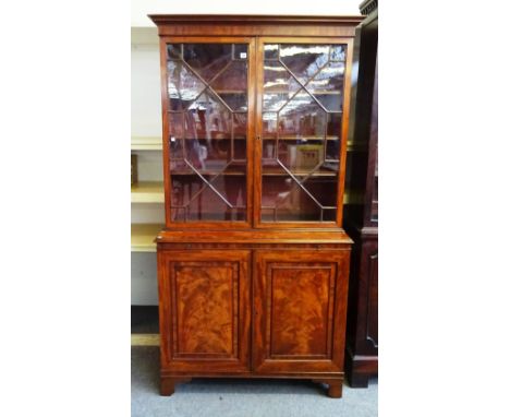 A George III mahogany bookcase cabinet, the pair of astragal glazed doors over brushing slide and pair of cupboard doors, on 