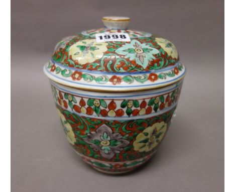A Chinese wucai jar and cover, 19th century or earlier, painted with flower medallions against an iron-red ground with green 