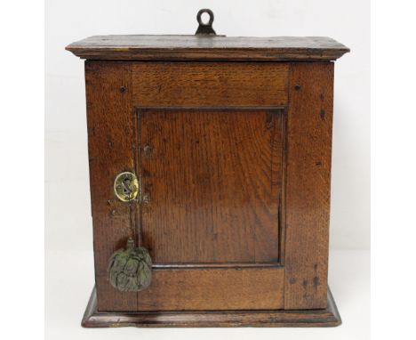 Small Georgian oak hanging cupboard of rectangular form, the panelled door opening to reveal three small drawers over two med