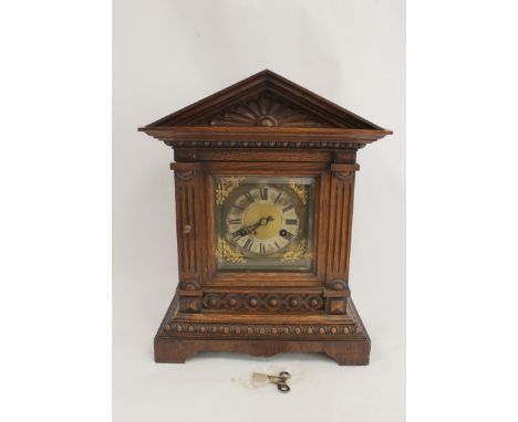 German mantel clock in carved oak case with pediment. 39cm. 