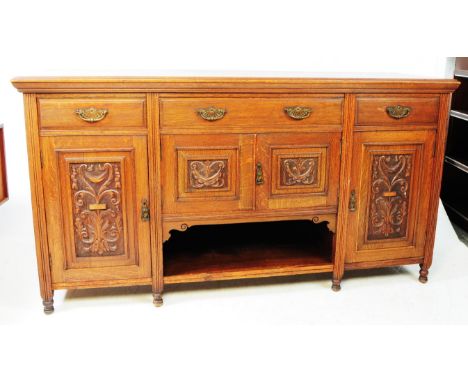 Victorian 19th century Arts &amp; Crafts oak sideboard in the manner of Liberty of London. The wide body comprising a series 