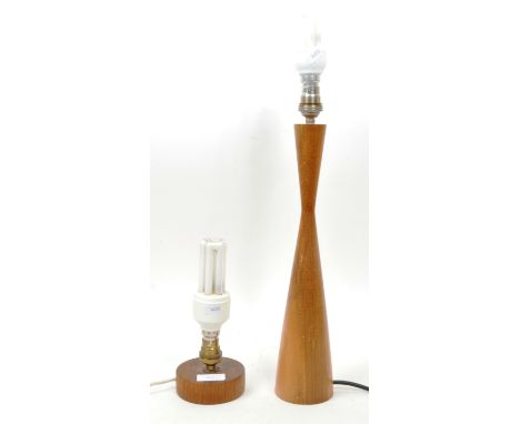A mid century teak wood table light. The teak wood base of circular form and squat design together with a tall teak wood skit