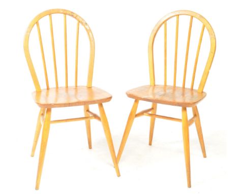 Ercol Furniture - A pair of mid century beech and elm wood stick back dining chairs. Raised on turned legs and stretchers, sa