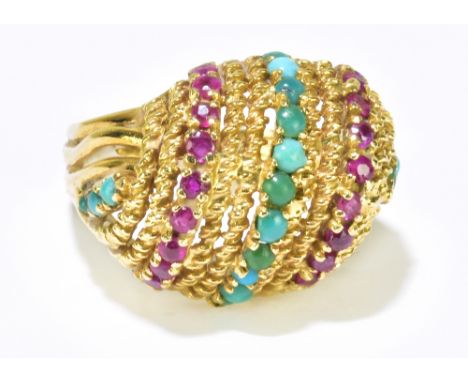An Eastern yellow metal domed ring set with bands of turquoise and rubies, size L 1/2, approx 9.6g.Additional InformationSome