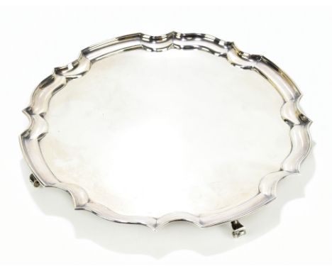 JAMES DIXON &amp; SONS; a George V hallmarked silver salver with cast scalloped edge, raised on four scrolling feet, Sheffiel