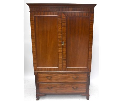 A 19th century mahogany linen press, with moulded cornice above two panelled doors enclosing a later hanging shelf and small 