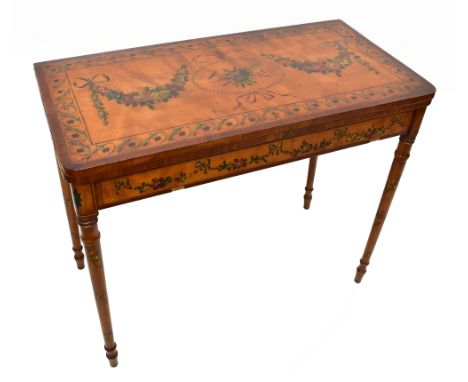 An early 19th century painted satinwood fold over games table of shaped rectangular form, the surface decorated with a shovel