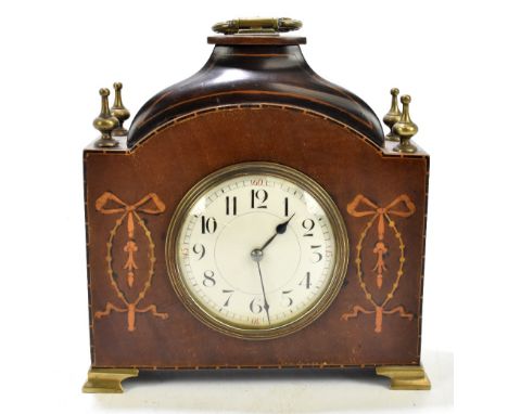 An Edwardian inlaid mahogany time piece, with four brass finials and central enamelled dial with both Arabic and Roman numera
