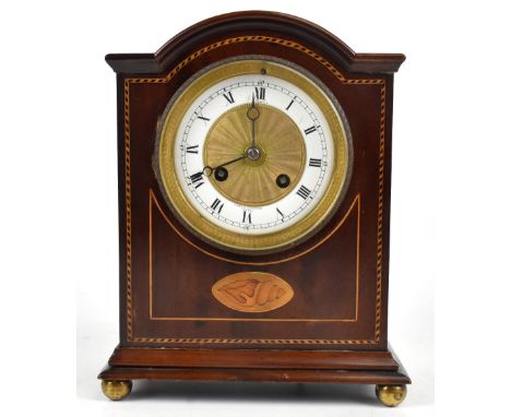 CLERKE; an Edwardian inlaid mahogany Sheraton revival mantel clock with arched top, the white enamelled dial set with Arabic 