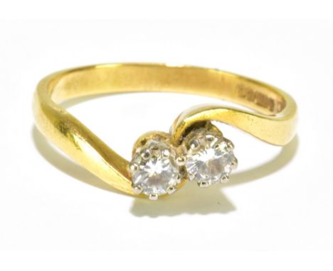 An 18ct yellow gold two stone crossover diamond ring, each round brilliant cut stone weighing approx 0.10ct, size M, approx 2