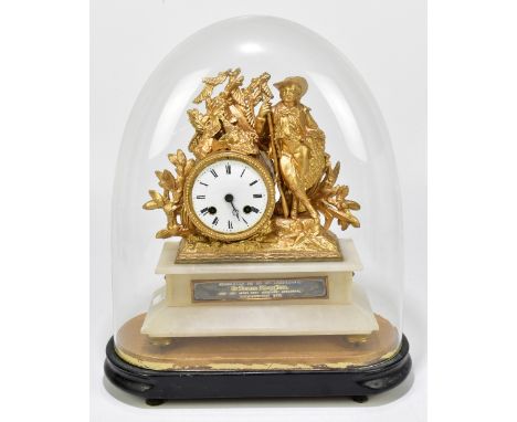 A late 19th century figural mantel clock with applied gilded pediments of a hunter leaning on his rifle beside the drum shape