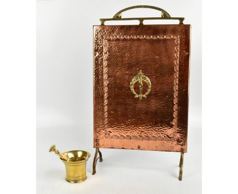 A hammered copper and brass fire screen, together with a brass mortar and pestle.&nbsp;