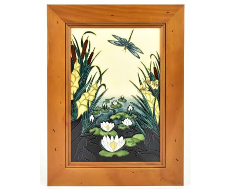 MOORCROFT; a ceramic rectangular plaque decorated with water lilies, bulrushes, and a dragonfly, framed, size of tile 31 x 20