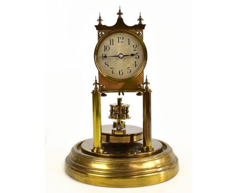 A gilt metal anniversary clock, the circular dial set with Arabic numerals, on circular base and presented beneath a clear gl