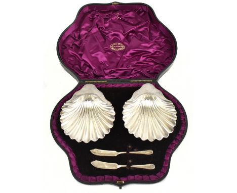 A pair of Victorian hallmarked silver shell shaped butter dishes, London 1887, with two associated butter knives, combined we