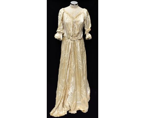 An Edwardian cream silk two piece skirt and blouse, comprising a full length satin skirt with tiered hem embellished with cre