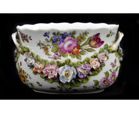 An early 20th century hand painted Continental porcelain planter of oval form, the floral decoration and applied floral encru
