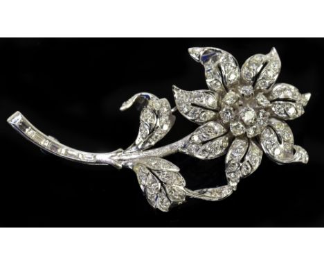 A white metal diamond set floral spray brooch, set with round brilliant cut stones to the main frame and with baguette cut st