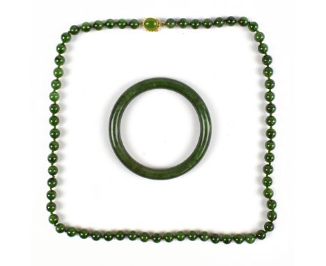 A green jade bracelet and set of jade beads with a silver gilt clasp with a cabochon jade stone, marked 925, length 70cm.