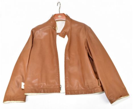 HERMÈS; a tan and cream leather reversible jacket with front zip and small collar, the jacket can be worn as a cream leather 
