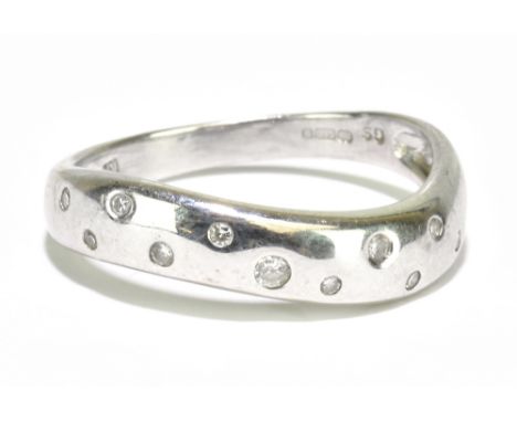 An 18ct white gold and diamond ring of serpentine form, set with eleven small size diamonds, the shank stamped '750', size N,