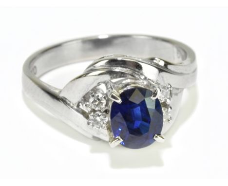 A white metal oval sapphire and four stone diamond ring stamped PT900, size K 1/2, approx 4.94g.