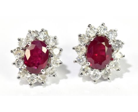 A pair of 18ct ruby and diamond ear studs, each set with oval ruby within a border of twelve diamonds, with butterfly backs, 