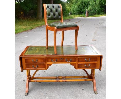 A reproduction yew wood veneered drop-leaf sofa table with green leather inset top above an arrangement of five drawers, with