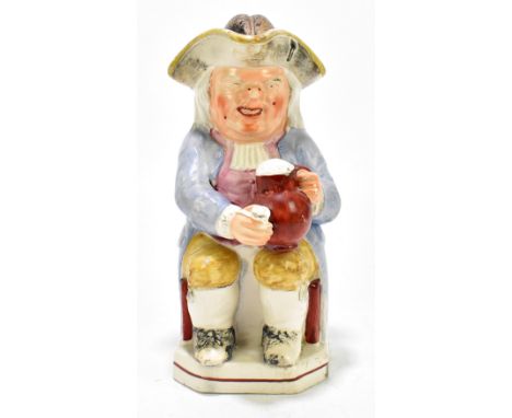A late 19th century Staffordshire Toby jug and cover modelled in the form of a portly gentleman holding a foaming mug and pip