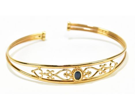 A 9ct yellow gold bangle with central opal, internal width 60mm, approx 5.1g.