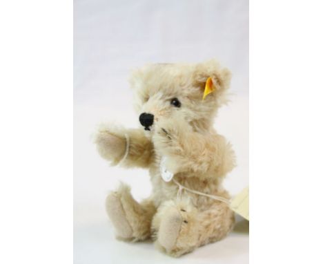 Modern Steiff seated blond teddy bear with button tag and original cardboard tag and labels